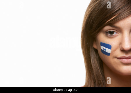 Junge weibliche Sportfan mit Honduras Flagge auf Gesicht gemalt Stockfoto