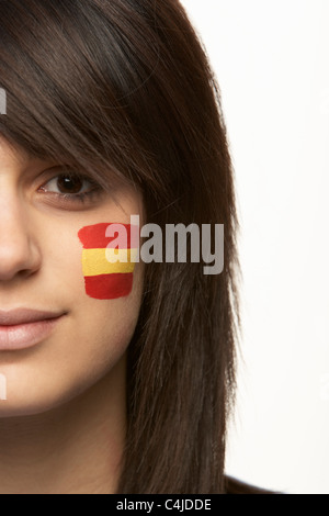 Junge weibliche Sportfan mit spanischen Flagge auf Gesicht gemalt Stockfoto