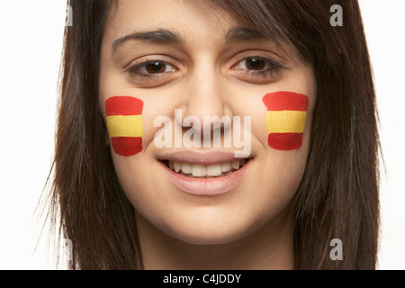 Junge weibliche Sportfan mit spanischen Flagge auf Gesicht gemalt Stockfoto