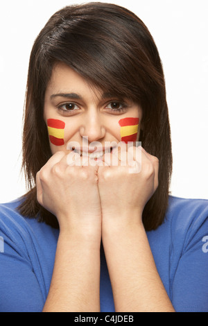 Junge weibliche Sportfan mit spanischen Flagge auf Gesicht gemalt Stockfoto