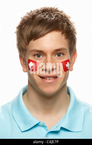 Junge männliche Sportfan mit Schweizer Flagge auf Gesicht gemalt Stockfoto