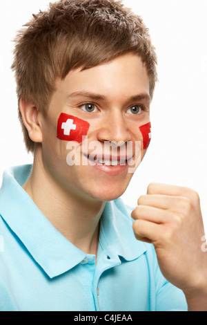 Junge männliche Sportfan mit Schweizer Flagge auf Gesicht gemalt Stockfoto