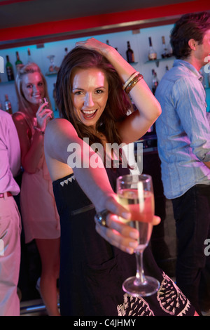 Junge Frau, die Spaß In belebten Bar Stockfoto