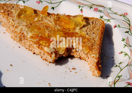 Geröstetes Vollkornbrot mit Butter und Marmelade auf einer achteckigen Platte, Westeuropa. Stockfoto