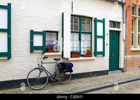 Weiß getünchte Ziegelhaus mit grünen Fensterläden getrimmt und Haustür in Brügge, Belgien Stockfoto