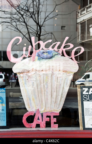 ansprechende große lackiert Holz Sperrholz Ausschnitt repräsentieren eine Geeiste Cupcake im Fenster des Hells Kitchen Café New York City Stockfoto