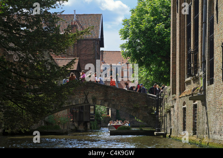 Touristen überqueren die kleinste Brücke in Brügge, Belgien. Stockfoto