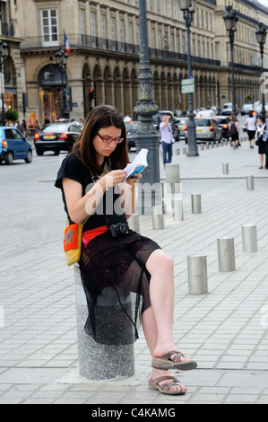 Ein Tourist einen Reiseführer in Place Vendome, Paris lesen Stockfoto
