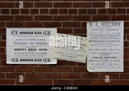 Altmodische fliegen Poster auf eine Mauer: norwegische Ice Company, Mais und Heu Müller, Beerdigung Anbieter. Stockfoto