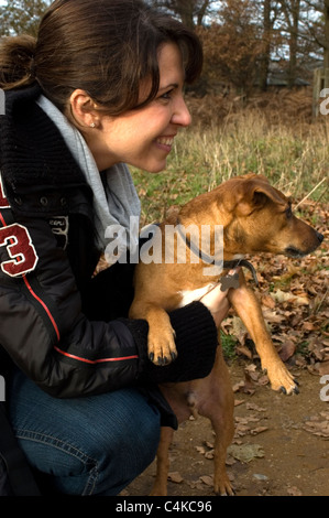 Lächelnde Frau hält ihren Jack Russel Hund in einem Park. Stockfoto