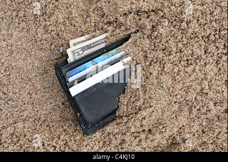 Eine verlorene Brieftasche am Strand mit Bargeld und Kreditkarten Stockfoto