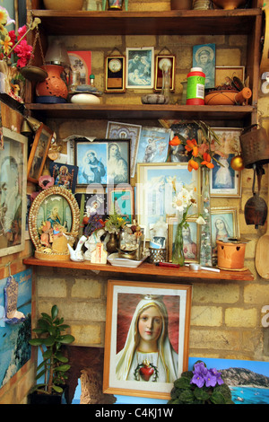 römische katholische Bilder, Gegenstände und Souvenirs in den Regalen im italienischen Heimat England Stockfoto