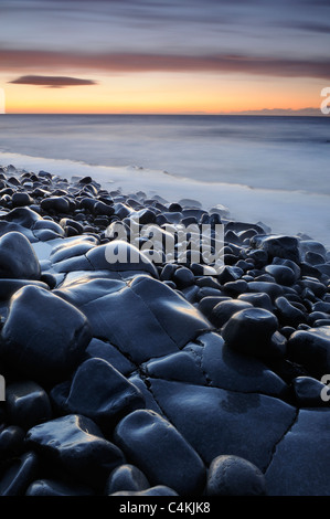 Nassen Felsen und Felsformationen am Strand von Kilve, Somerset, bei Sonnenuntergang. Stockfoto