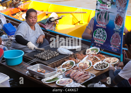 Thai Frau Zubereitung und Verkauf von Lebensmitteln in Amphawa schwimmenden Markt, Thailand Stockfoto