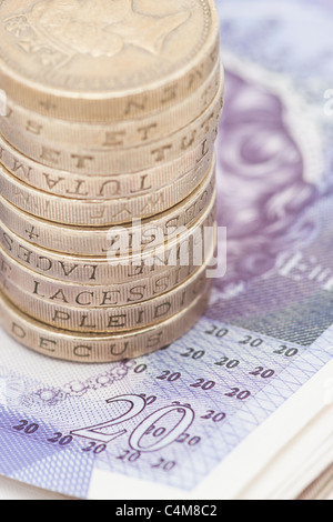 Nahaufnahme der Stapel / Haufen von einem Pfund-Münzen auf der Oberseite 20-Pfund-Noten Stockfoto