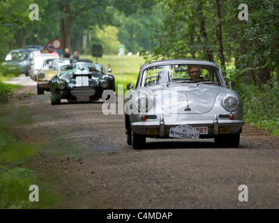 Oldtimer-Rallye in der belgischen Landschaft, Porsche 356 vor gefolgt von AC Cobra und einen klassischen 911 Porsche. Stockfoto