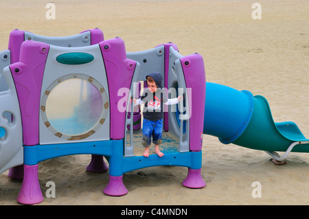 Ein kleiner Junge auf einem Spielplatz am Strand bei Avon-by-the-Sea, New Jersey Stockfoto