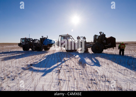 Arbeiter um seismische Vibrator-LKW, die für Öl & Erdgas Exploration verwendet werden Stockfoto