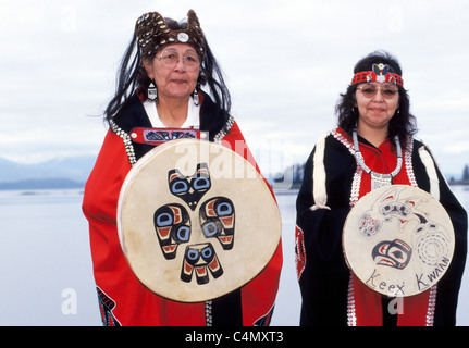 Zwei Tlingit Indianer Frauen zeigen traditionelle Umhänge mit Knöpfen und Trommeln des Keex-Stammes (Kwaan) an Kake, Alaska, USA entwickelt. Stockfoto