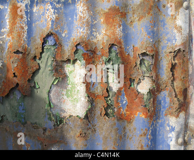 Alten läutenden Farbe auf eine rostige Wellblech-Wand Stockfoto
