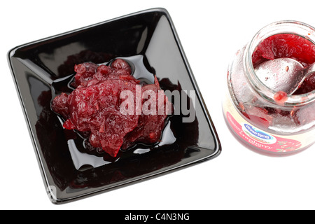 Cranberry-Sauce in eine schwarze Schale Glas und Löffel serviert Stockfoto