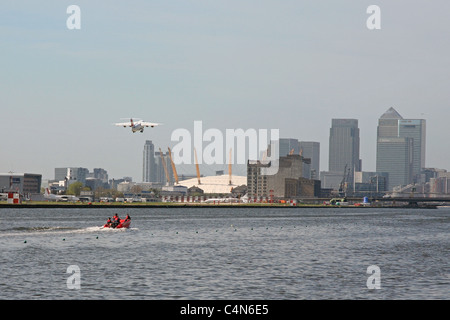 Flugzeug verlassen London City Airport über die Themse in die East London Skyline Stockfoto