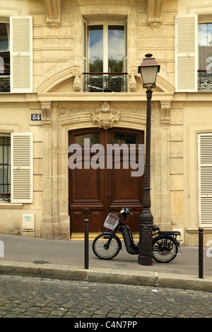 Eine typisch französische Straße in Montmartre, Paris, mit einem Motorrad auf einen Laternenpfahl gelehnt Stockfoto