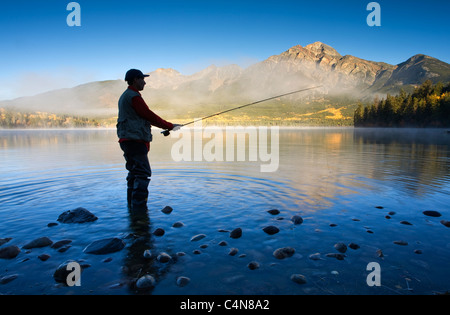 Mittleren Alters männlichen Fliegenfischen im Pyramid Lake, Jasper Nationalpark, Alberta, Kanada. Stockfoto