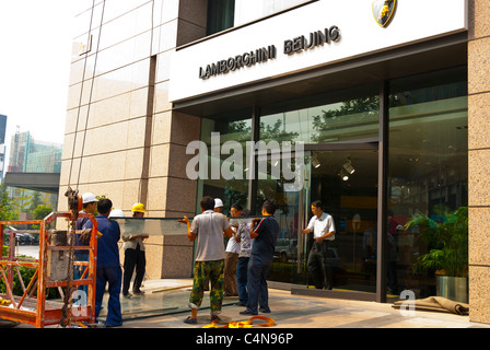 Peking, China, Gruppe chinesischer Arbeiter, die schwere Glasplatten auf der Baustelle im Stadtzentrum, Eingang des Lamborghini-Gebäudes tragen Stockfoto