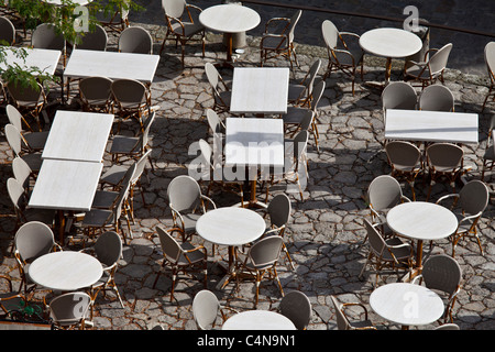 Leere Tische im Straßencafé und Kopfsteinpflaster in St. Emilion, Bordeaux Region von Frankreich Stockfoto