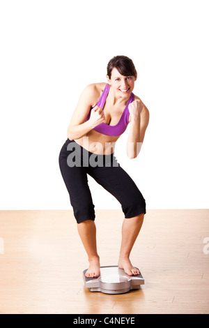 Porträt von einem schönen sportlichen Mädchen Überprüfung ihres Gewichts, isoliert auf weiss Stockfoto