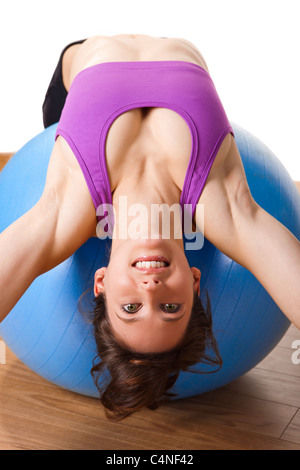 Schöne junge und sportliche Frau, die die Übungen auf einer Fitness-ball Stockfoto