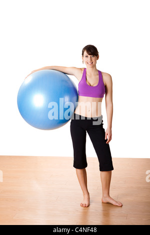 Schöne junge und sportliche Frau, die die Übungen auf einer Fitness-ball Stockfoto