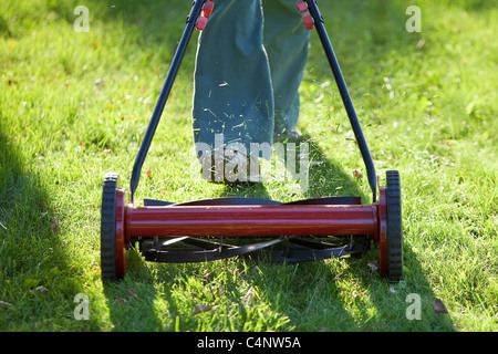 Frau mit einem umweltfreundlichen Push-Rasenmäher Rasen zu mähen.  Winnipeg, Manitoba, Kanada. Stockfoto