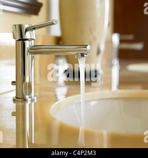 Nahaufnahme der Badezimmer Wasserhahn mit fließendem Wasser und Marmor-Arbeitsplatte, Victoria, Vancouver Island, b.c., Kanada Stockfoto