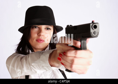 Schöne junge Frau mit Hut mit Krempen Zielen mit der Waffe. Stockfoto
