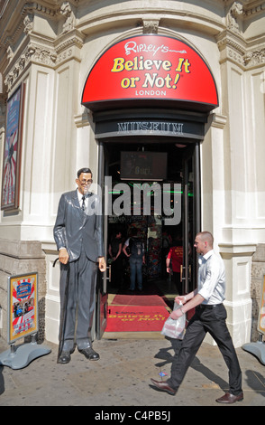 Durchschnittliche Höhe Mann geht hinter dem Eingang um Ripleys glauben es oder nicht am Piccadilly Circus, London, UK. Stockfoto