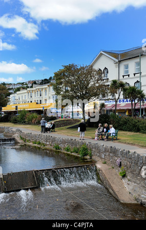 Bewohner und Touristen nehmen Sie am Flussufer im Rasen Park Bereich Dawlish Devon England Vereinigtes Königreich Stockfoto