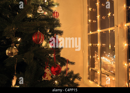 Weihnachtsbaum und Fenster mit Weihnachtsbeleuchtung Stockfoto