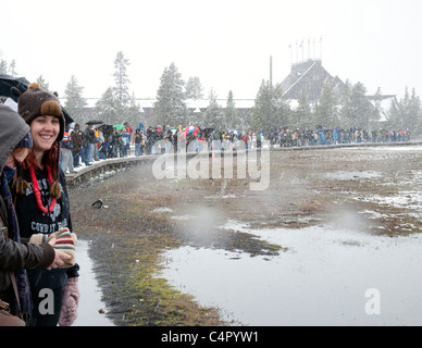 Große Anzahl von Menschen warten in einem Schneesturm für Old Faithful Geysir, ausbrechen Stockfoto