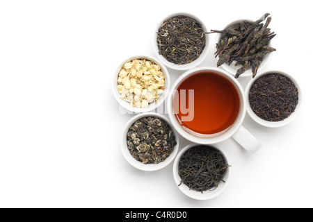 Schwarzer Tee in weiße Tasse mit Teeblätter und Blüten. Stockfoto