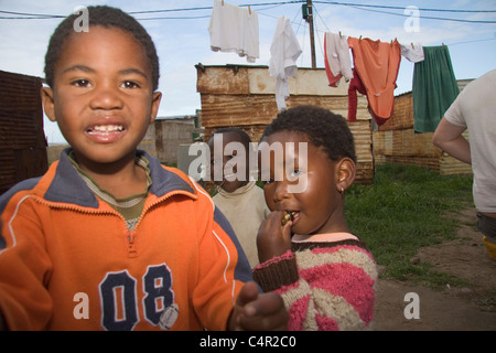 Kinder im Freien mit Wäsche im Hintergrund, Jeffreys Bay, Südafrika Stockfoto