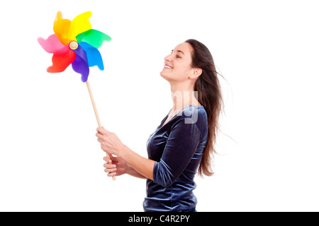 schöne junge Frau hält ein buntes Windrad - isoliert auf weiss Stockfoto