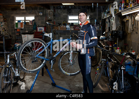 Irische Mountain Bike Champion Robin Seymour hält sein Fahrrad in einer Garage in der Grafschaft Wicklow, Irland Stockfoto