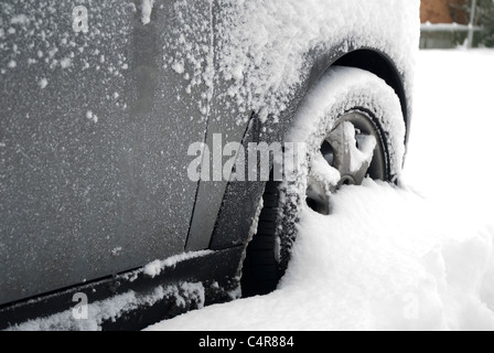 Starker Schneefall trieb gegen geparkten Autoreifen Stockfoto