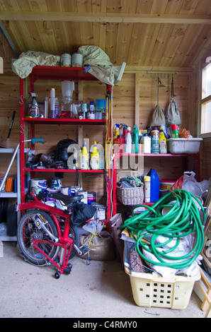 Regale in einem Gartenhaus mit Garten und allgemeine Werkzeuge und Ausrüstungen verpackt Stockfoto