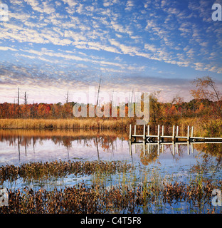 Ein kleines Boot und Angelsteg unter schönen Morgen Himmel auf See sechzehn im Herbst, Oakland County Michigan. USA Stockfoto
