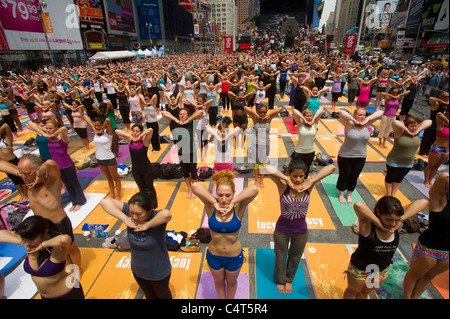 Tausende von Yoga-Praktizierende auf dem Times Square in New York teilnehmen, in einer Gruppe Yoga Beobachtung der Sommersonnenwende Stockfoto