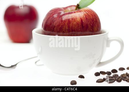 Äpfel in eine Schüssel, Löffel und Kaffeebohnen isoliert auf weiss Stockfoto