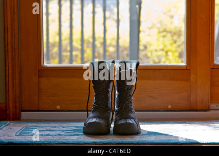 Schuhe, die durch eine Tür sitzen. Stockfoto